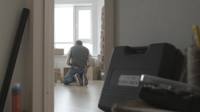 Man is looking for something in a box, general view