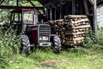 Old tractor front view in germany countryside old abandoned barn firewood wood stacked