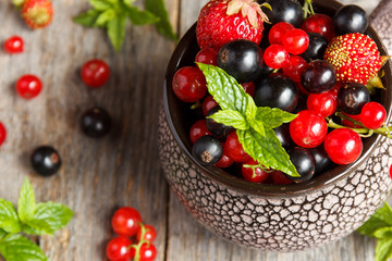 Fresh berries. Various summer berries in a bowl on rustic wooden table.
