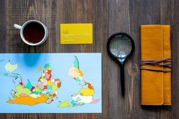 Planning trip. World map, compass and bank card on wooden table background top view