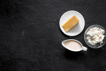 Non GMO, prservatives-free organic food. Milk, cottage and cheese on black stone background top view copyspace