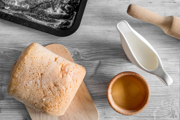 Make bread. Loaf and ingredients on light woden table background top view