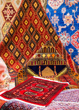 Oriental carpets in the market. Mosque image on one of the rugs.