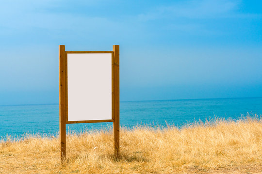 Beautiful view of water, sky and horizon and a large sign with copy space in the foreground.