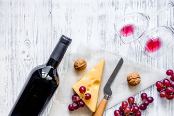 Wine snack. Cheese, nuts, grape on light wooden table background top view copyspace