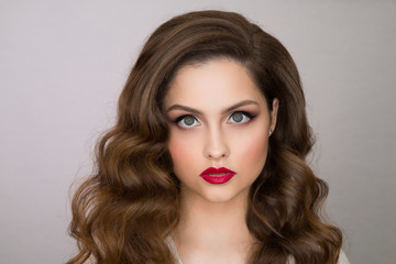 Fototapeta premium Portrait of a beautiful young girl with makeup and hairstyle