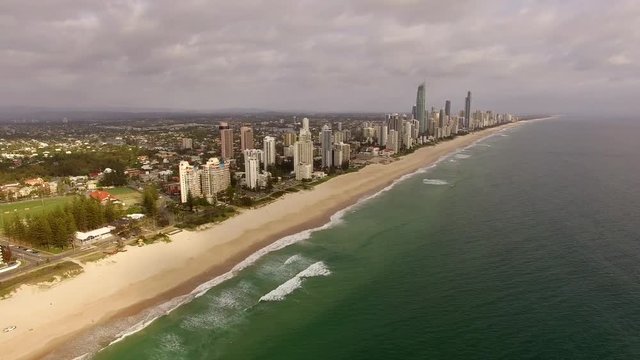 Bird eyes view of Goald coast Australia on a cloudy day camera above ocean flying toward skyscrapers