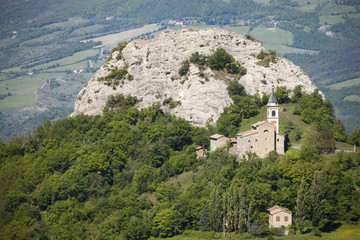 Fototapeta na wymiar Italia, Appennino Tosco Emiliano, una chiesetta a ridosso di una collina sull'appennino.