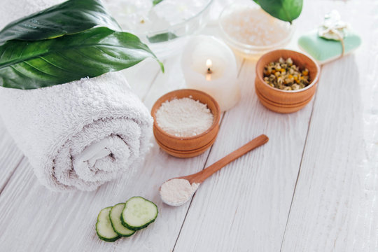 Spa essentials including candle, salt, herbs and white clay