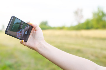 Young beautiful girl doing selfie at sunset