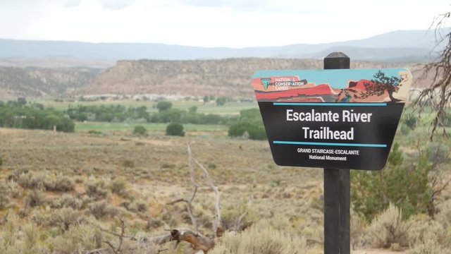 A sign for the Escalante River Trailhead sits off the road in rural Escalante, UT.