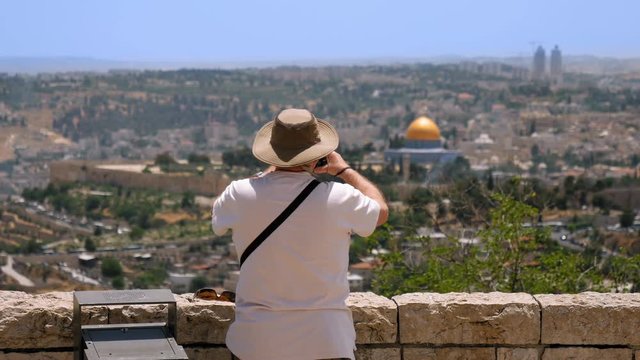 Tourist takes a photo of Jerusalem Old City view. Mount Scopus is a famous Holy Land place and it has a fantastic view to the Old Jerusalem. Jerusalem is a beautiful and popular touristic city.