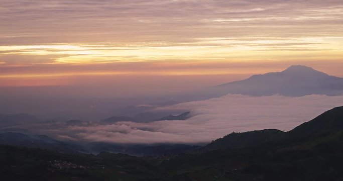 Beautiful time lapse of foggy Dieng Plateau at sunrise time, shot from mount Prau, Wonosobo, Central Java, Indonesia. Shot in 4k resolution