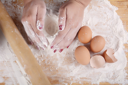 Woman hands knead dough.