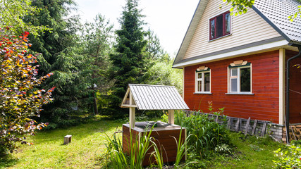 view of cottage and well from backyard in country