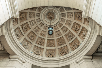 Vaulted ceiling with central lamp in a neoclassical building seen from below