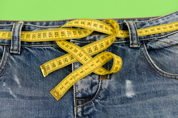 Blue jeans with yellow measure tape instead of belt