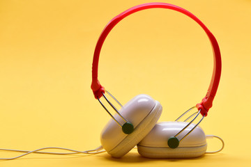 Modern and stylish earphones on light orange background