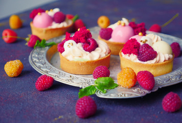 Cakes with strawberries and berries. Raspberry Cakes on dark background. Tasty Raspberry Tarts on a Vintage Plate. Wonderful Sweet Desserts. Mini tarts with Raspberries. Raspberry fruit tart.