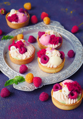 Cakes with strawberries and berries. Raspberry Cakes on dark background. Tasty Raspberry Tarts on a Vintage Plate. Wonderful Sweet Desserts. Mini tarts with Raspberries. Raspberry fruit tart.