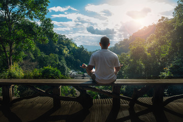 Man doing yoga and meditation over beautiful landscape.