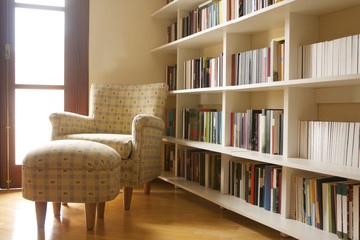 Home library with arm chair. Clean and modern decoration.