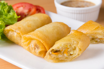 spring rolls on white plate with sauce