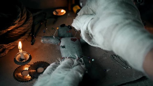 the mage conducts a ritual with a voodoo doll and sticks pins in it
