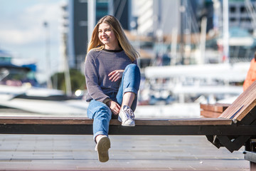 outdoor portrait of young happy smiling teen girl on marine background on a sunny day, auckland...