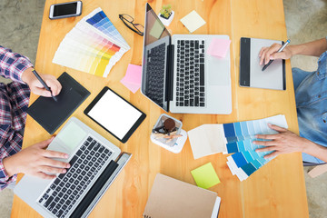 Naklejka premium Graphic design partners working together renovation and technology concept - on a desktop computer and selection using some color swatches.