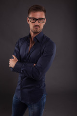 Young confident man portrait of a confident businessman showing by hands on a black background. Ideal for banners, registration forms, presentation, landings, presenting concept.