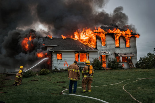 Firefighters using water to put out a house fire.