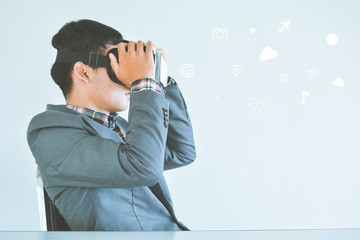 Asian businessman playing VR virtual reality glass box with icon selective and soft focus