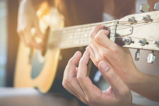 Men's hands are teaching women to play guitar.This image is blurred and Soft focus.