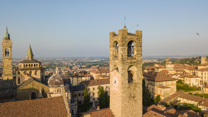 Fototapeta na wymiar Bergamo, old city, drone aerial view of the Basilica of Santa Maria Maggiore and the bell tower. On the background the Padana plain