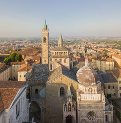 Obraz premium Bergamo, old city, drone aerial view of the Basilica of Santa Maria Maggiore and the chapel Colleoni. In the background the Padana plain