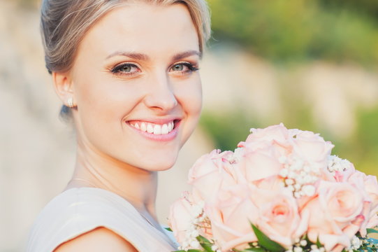 Beautiful smiling bride with wedding bouquet