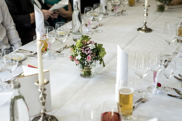 Table setup at marriage waiting for guests with dishes water flowers