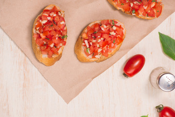 Italian bruschetta with roasted tomatoes, mozzarella cheese and herbs on a paper
