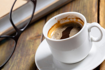 Vintage book and a cup of coffee on wooden background