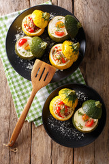 Green zucchini baked with eggs and yellow zucchini stuffed with bulgur close-up. Vertical top view