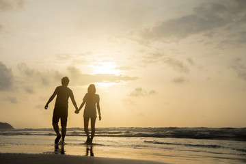 Romantic Retired Couple Relaxing on Beach Vacation at Sunset