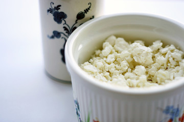 Food. Cottage cheese in a plate, a milk jug and on a table with a white tablecloth. Healthy food.