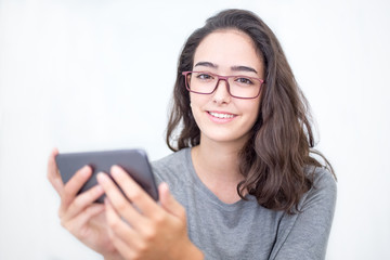 Fototapeta premium Positive young woman in glasses holding smartphone