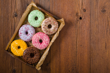 Colorful donuts on a wooden background.