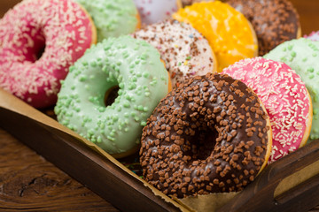 Colorful donuts on a wooden background.