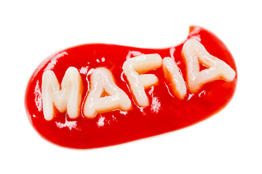 Inscription MAFIA made from pasta in a drop of red tomato sauce on a white background. Isolated