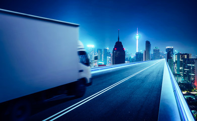 Truck traveling on road at night - speed and delivery concept.