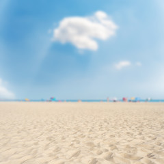 sand beach closeup under clouds in blue sky. soft focus in bottom of picture