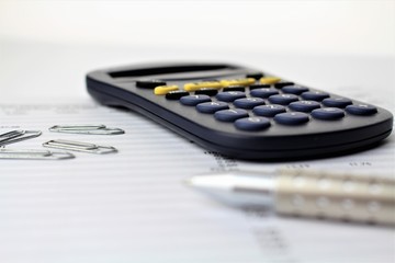 An Image of a paper with calculator and pen (Focus in the middle)